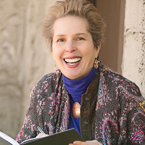 Headshot of a woman smiling holding a journal